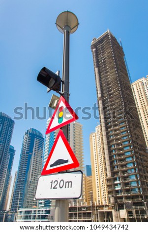 Road signs on a pole against a background of city skyscrapers