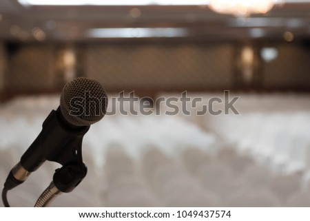 
Microphone over the abstract blurred photo background.
Abstract blurred photo of conference hall or seminar room with attendee background. 
Business board meeting concept.