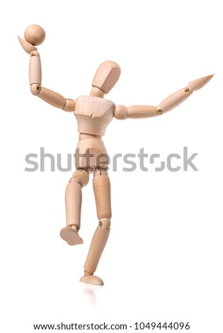 Wooden manikin dancing with a ball isolated on white background