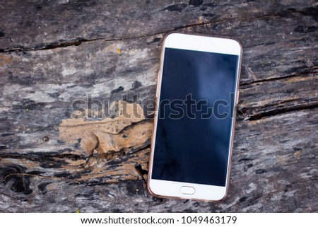 White smartphone on a wooden background.