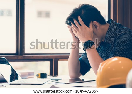 Exhausted/tired/sad/disappointed/frustrated young asian engineer/architect/businessman working at factory job site  Royalty-Free Stock Photo #1049472359