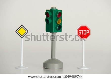 Traffic light road sign, red stop sign and priority/ main road road sign in studio against white background. Traffic regulatory warning signals and signs. 
