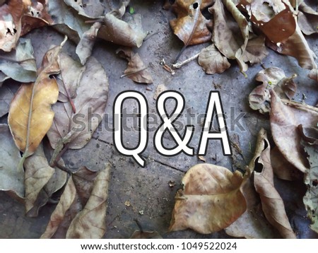 Questions and Answers Q&A concept. Word - Q&A with dry leaf on wooden background.

