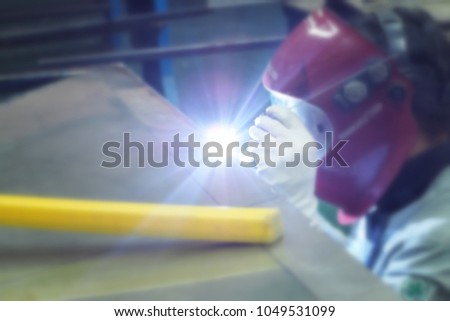 Blur/Welder is welding Gas Tungsten Arc Welding process. Have a glare and sparks from stainless table in in workshop.
