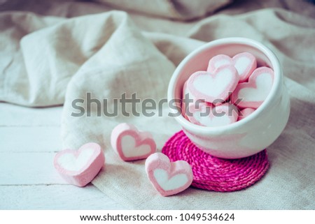 Heart shape marshmallows in white mug on wood background, sweet and  love concept