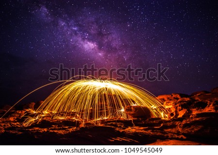 night sky with milky way.Swirl Steel Wool light Photography  over the rock and water at night  Sam Phan Bok.Photo by long exposure with noise and grain.