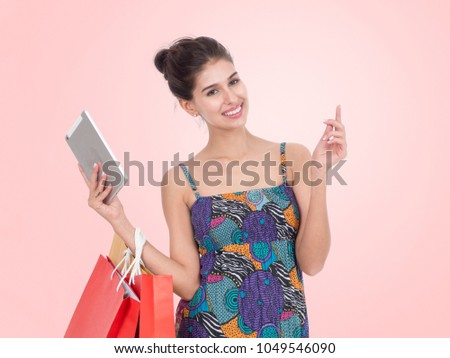 Picture showing pretty woman shopping online with smart tablet.Portrait of young happy smiling woman with shopping bags.