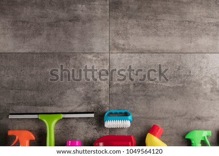 Cleaning concept. Colorful cleaning products on gray tiles. Place for typography.
