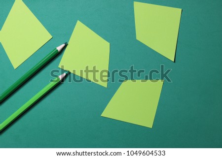 Pencils on green paper of geometric shapes. The concept of drawing on paper.