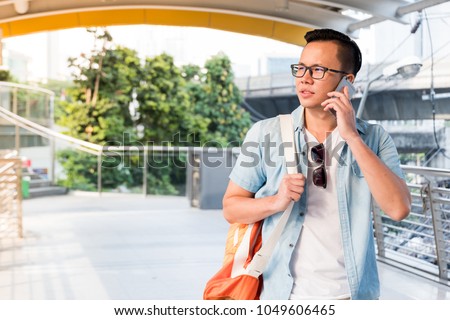 A traveler man with sun glasses is talking on the mobile phone for Confused mood. Outdoor landscape.