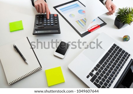 Close up view of bookkeeper or financial inspector hands making report, calculating or checking balance. Marketing strategy brainstorming. Paperwork and digital in office.