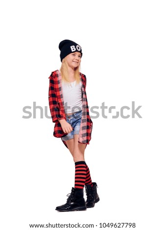 A blond, pretty girl wears a shirt and a black knitted cap. She jumps, tilts her legs, smiles and has fun. Shot on a white background in the studio.