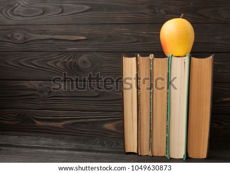 Stack of old books, wooden background, free copy space Vintage old hardback books on wooden shelf on the deck table. Back to school. Education background. Books and Apple With Chalkboard.