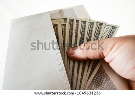 Human male hand holding 100 hundred dollars bills currency letter envelope. isolated on white background 