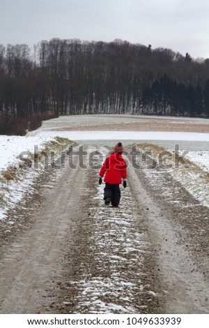 A little girl is walking alone on the country road farm on a path for a freedom or happiness concept.