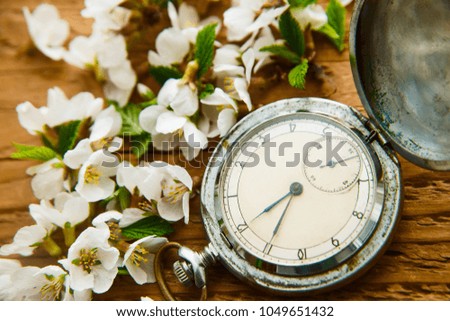 Vintage Pocket watch and white flowers of apple tree on a wooden table background. spring time season. springtime season idea, sign, symbol, concept