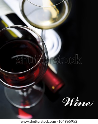 Glass of red and white wine on black background. Wine list design with copyspace.