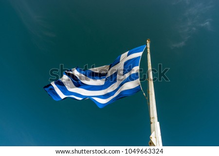 Flag of Greece on flagpole against the blue sky