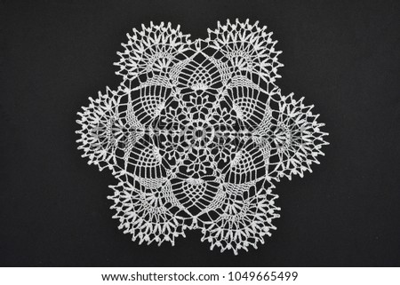 Crocheted lace napkin as home decoration on black
