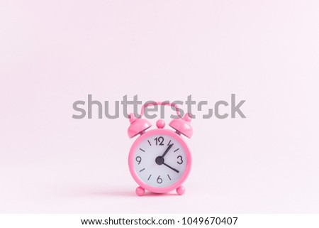 Alarm clock on pastel pink background. Space for copy. Minimal concept.