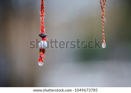Martenitsa with smile and water drop under the rain