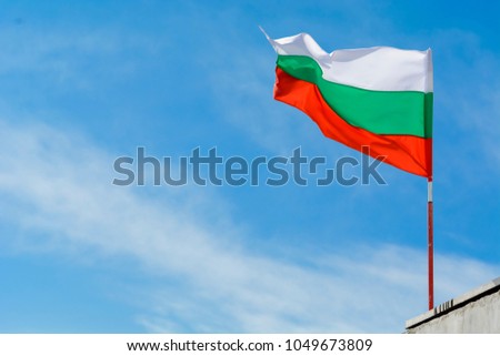 Bulgarian flag waving against vibrant blue sky