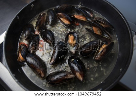 Stewed mussels in wine in a frying pan