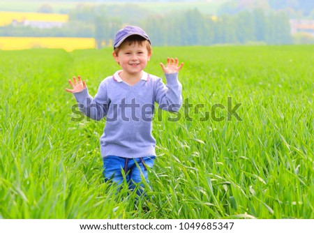 A country boy playing in green wheat field. Happy life on Czech countryside. People and sustainable development in European Union.