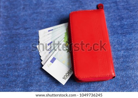 money in a red purse on a blue background