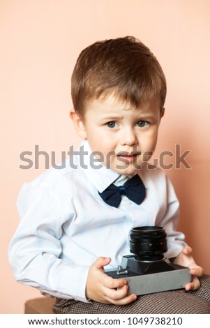Little boy with aged retro camera. Young photographer. Child with an old camera