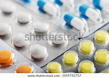 Heap of medical pills in white, blue and other colors. Pills in plastic package. Concept of healthcare and medicine. Royalty-Free Stock Photo #1049742707