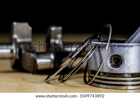 Crankshaft, piston and other parts of the internal combustion engine. Disassembled single-piston four-stroke engine on the workbench. Black background.