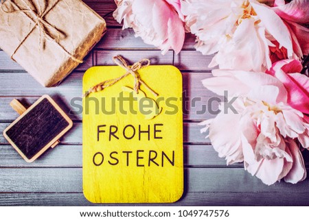 Happy Easter in german language. peonies flowers close-up with easter chalkboard, gift box and sale chalkboard on wooden background. easter mock-up template. easter sale, greeting card concept.