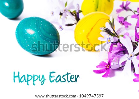 close-up of colorful easter eggs and phlox flowers on white background with copy space. border template, easter greeting and holiday card.