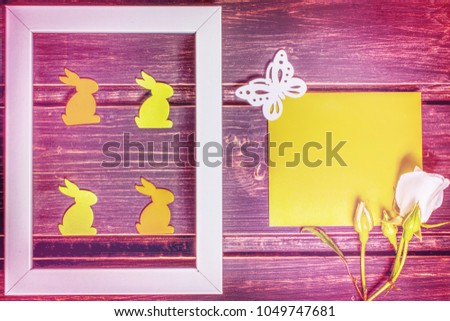 Happy Easter mockup. close-up of wooden easter rabbits in photo frame. white rose flowers on green card template with copy space. easter sale, greeting and celebration card concept.