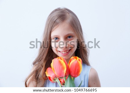 Portrait of a charming little girl with flowers on a white background.