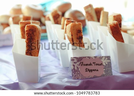 A display of individual French Toast Dippers on a table cloth at a party