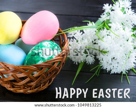 Easter eggs and white flowers on a background of grass with a congratulatory text