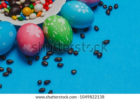colored easter eggs on a saucer on a blue background
