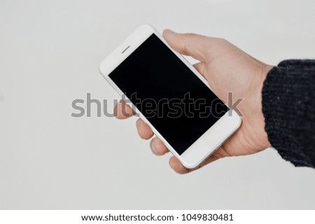 Hand hold mobile phone, person using smartphone. Top view closeup on black screen digital device mock up. Marketing technology design surface background, communication lifestyle
