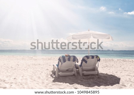 Sun umbrellas and beds at seaside, perfect summer vacation Royalty-Free Stock Photo #1049845895