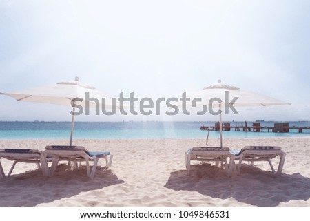 Sun umbrellas and beds at seaside, perfect summer vacation Royalty-Free Stock Photo #1049846531