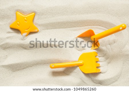 Bright plastic children's toys in the sand. Concept of beach recreation for children. Top view. Space for text. Royalty-Free Stock Photo #1049865260