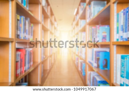 Blurred images of Bookshelf Research of Education in library and Light sunset.
