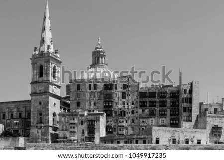 Cityscape view with Basilica of Our Lady of Mount Carmel on the island of Malta. Buildings with traditional colorful maltese balconies in historical part of Valletta. Black and white picture