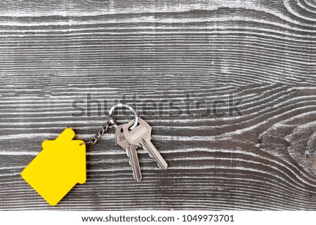 keys from the living space with a keychain in the form of a house on the background of a wooden table. sale. 