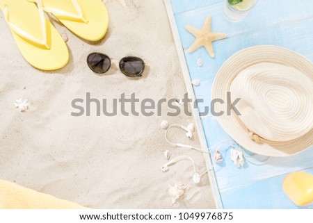 Traveler accessories on sand. Straw hat, sunglasses, flip flops, cocktail, sunblock with copy space. Travel vacation concept. Summer background