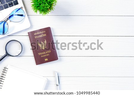 The thai people worker and employee desk has trip dreaming and preparing to journey and travel around the world with laptop and thailand passport on white wood table from flat lay top view.