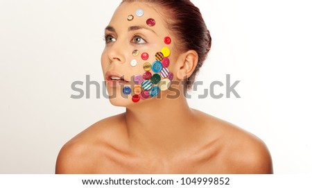 Attractive woman, with various buttons on her face, looking up