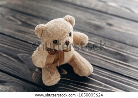 Cute plush teddy bear toy with a ribbon, flat lay view of nostalgic teddy bear toy for child or valentine's day gift, happy bear for loved one close-up